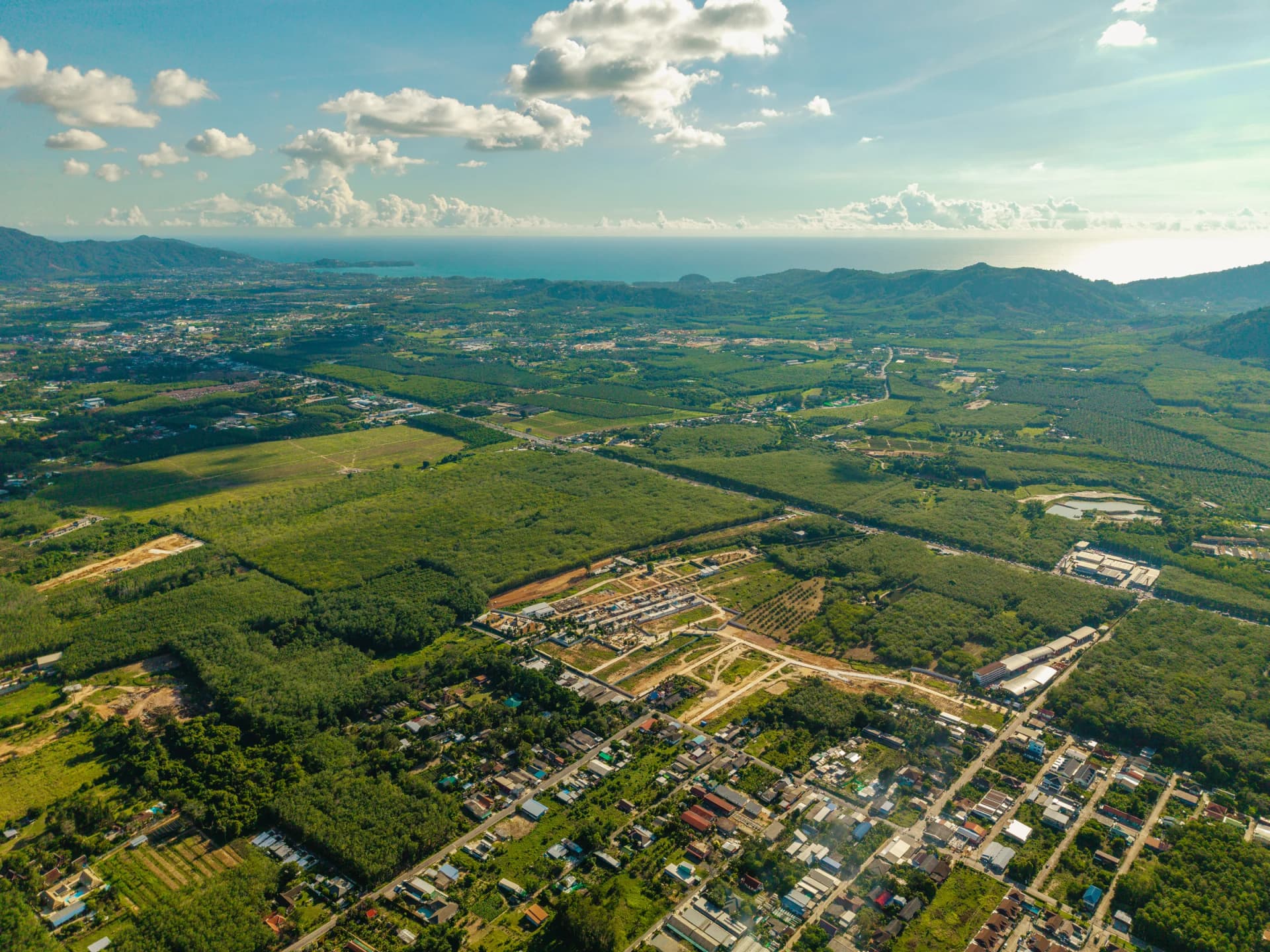 The Pa Khlong Cheep plateau from a drone: fields and rubber groves running to the forested mountains