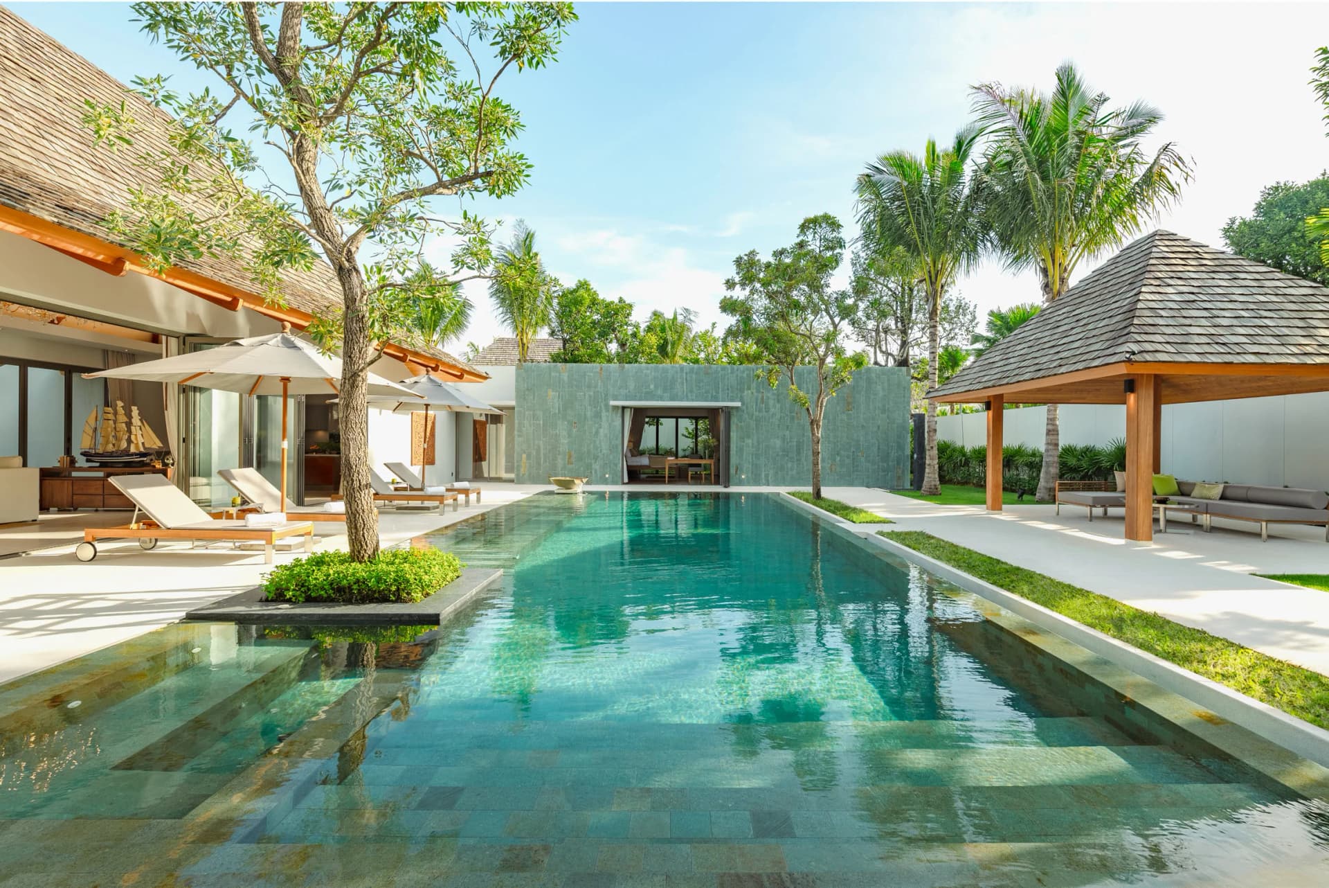 Long pool between cedar-roofed pavilions — built Anchan villa, same design team and materials